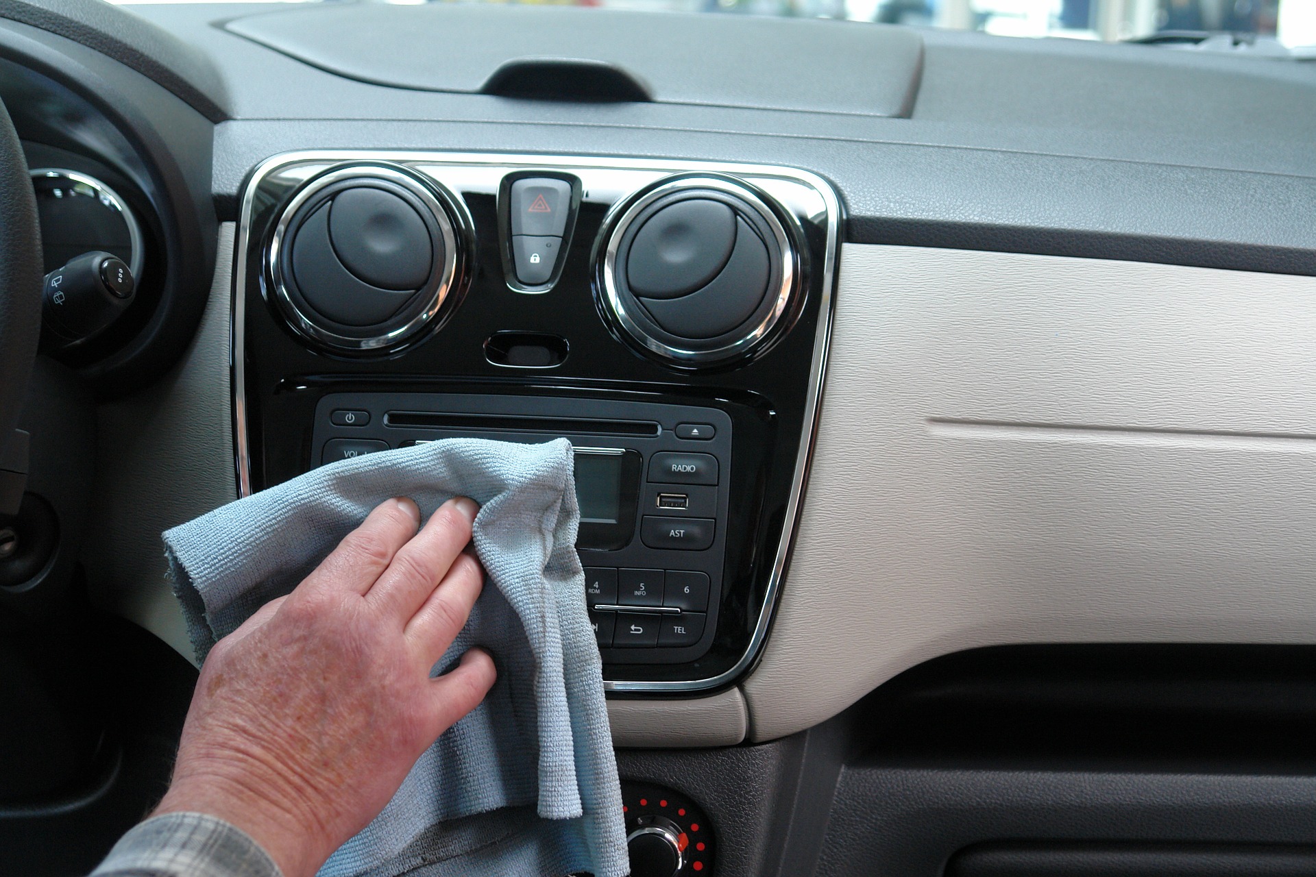 Up close of hand wiping off dashboard of vehicle