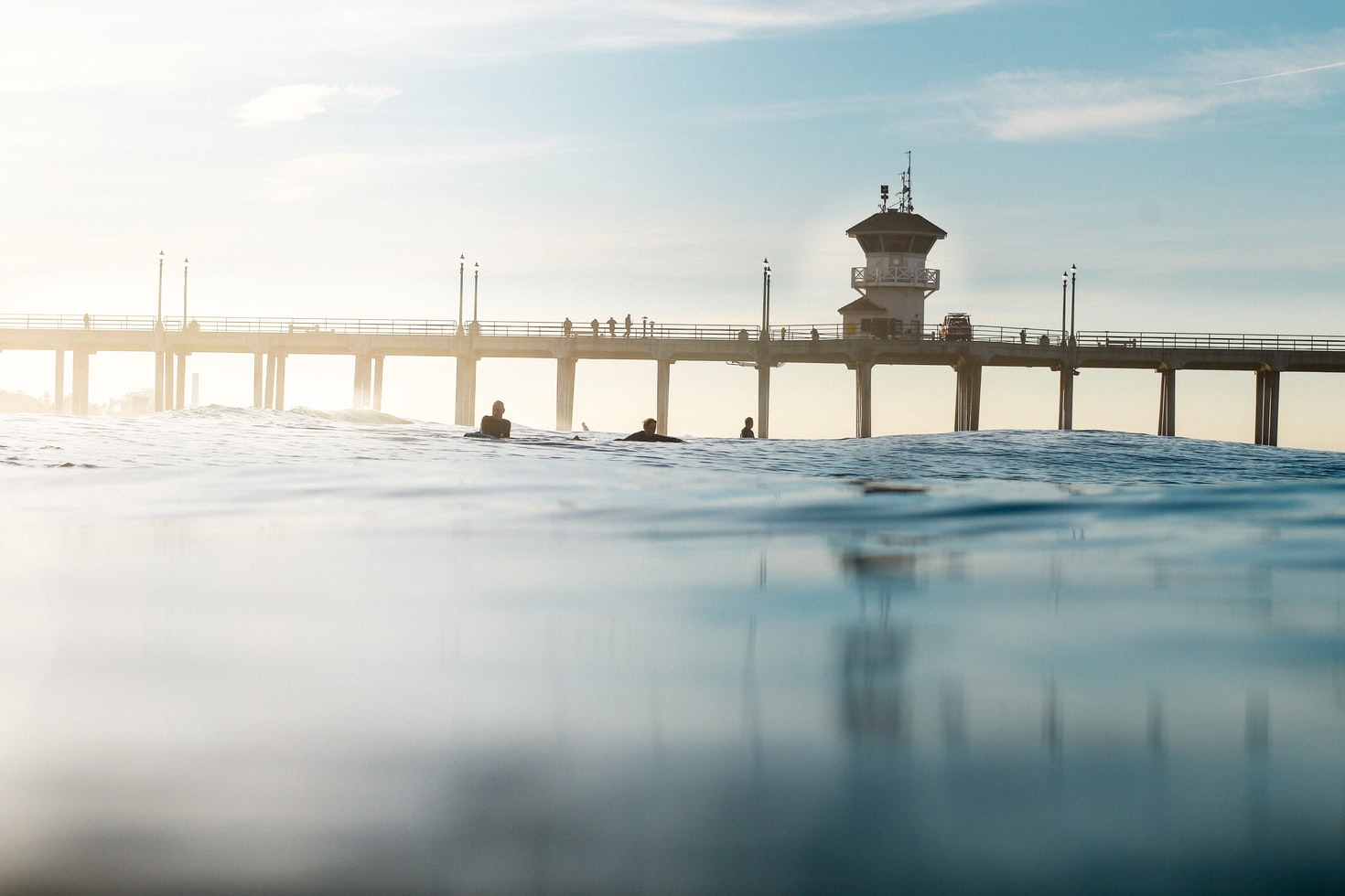 People swimming in water, dock in background